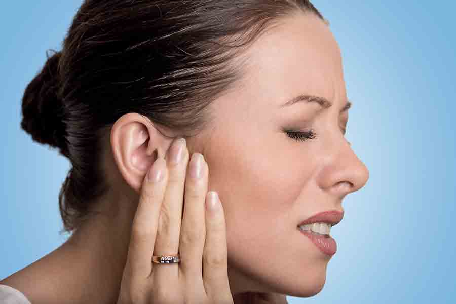 Jeune femme ayant mal à l'oreille a cause d'acouphènes.