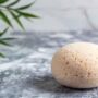 Une éponge konjac naturelle posée sur une table en marbre d'une salle de bain