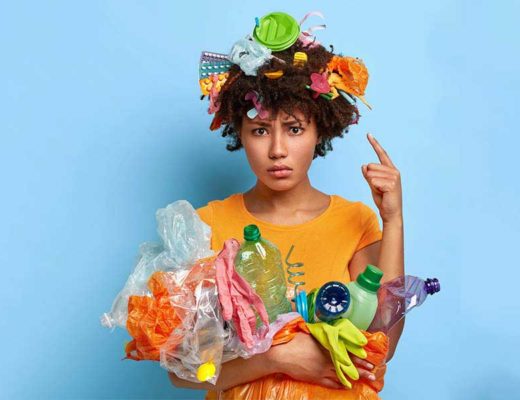 Concept de protection de l'environnement. Une femme afro mécontente entourée de déchets plastiques.
