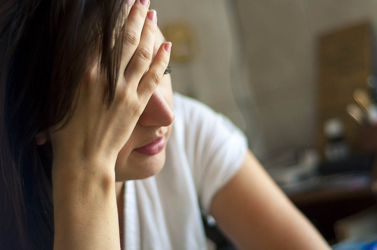 Une femme en état de stress face à ses inquiétudes avec des pensées négatives.